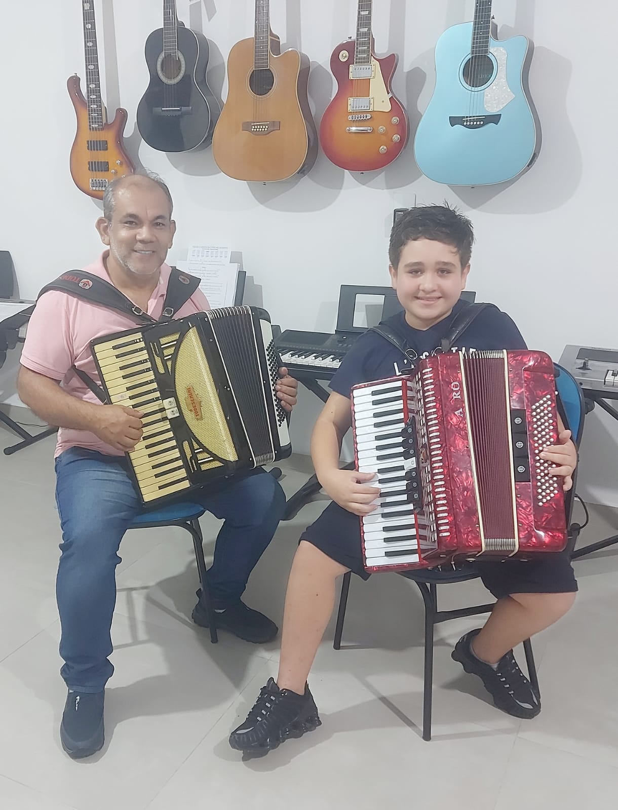 Professor e aluno com acordeons