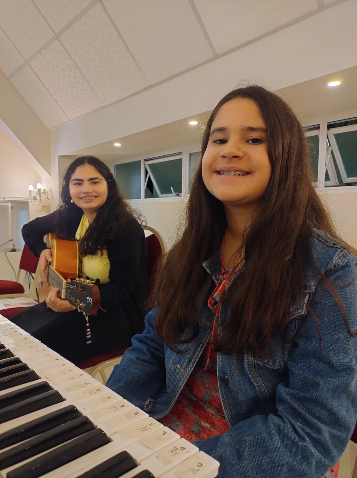 Alunas em aula de teclado e violão